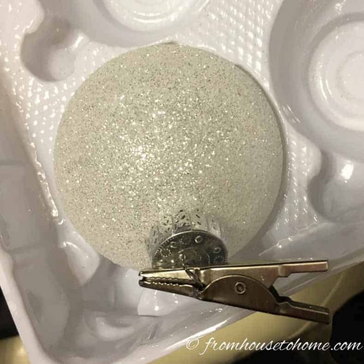 White Christmas ornament with an alligator clip attached to it