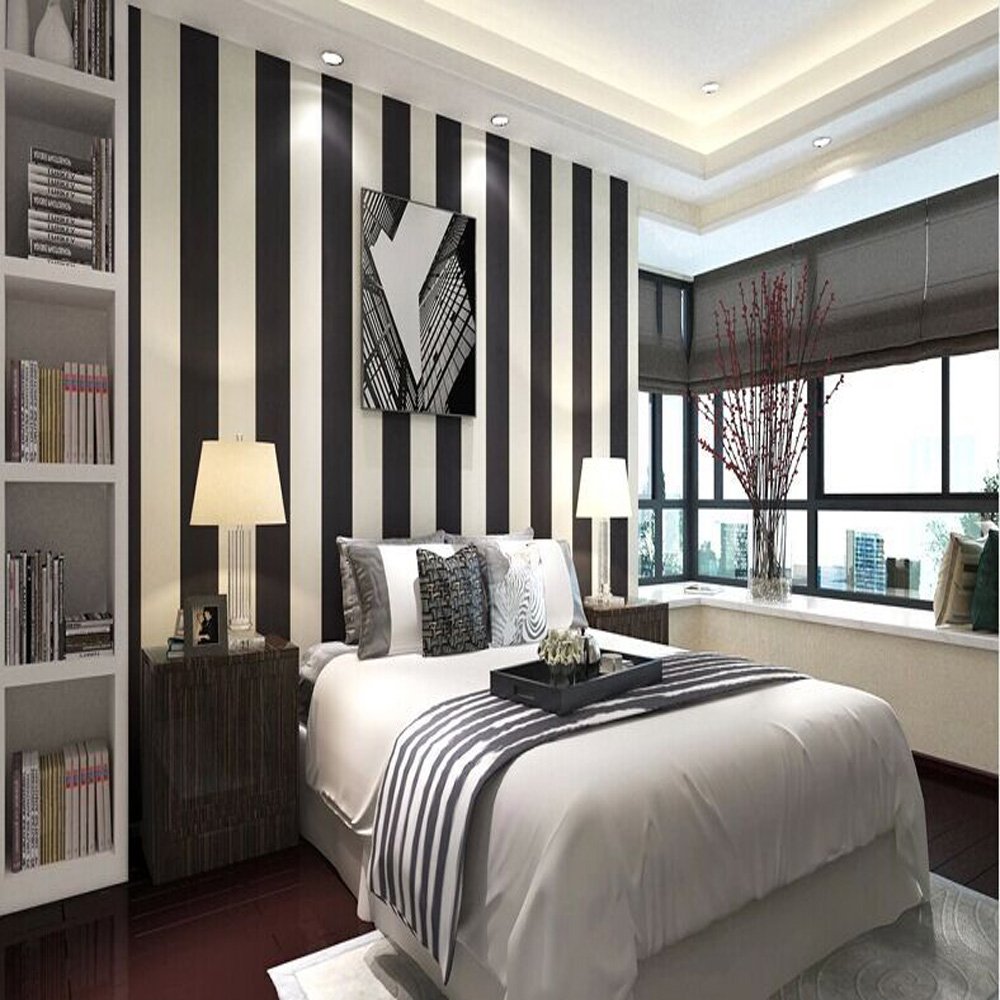 Bedroom with black and white vertical striped wallpaper that make the ceiling look taller