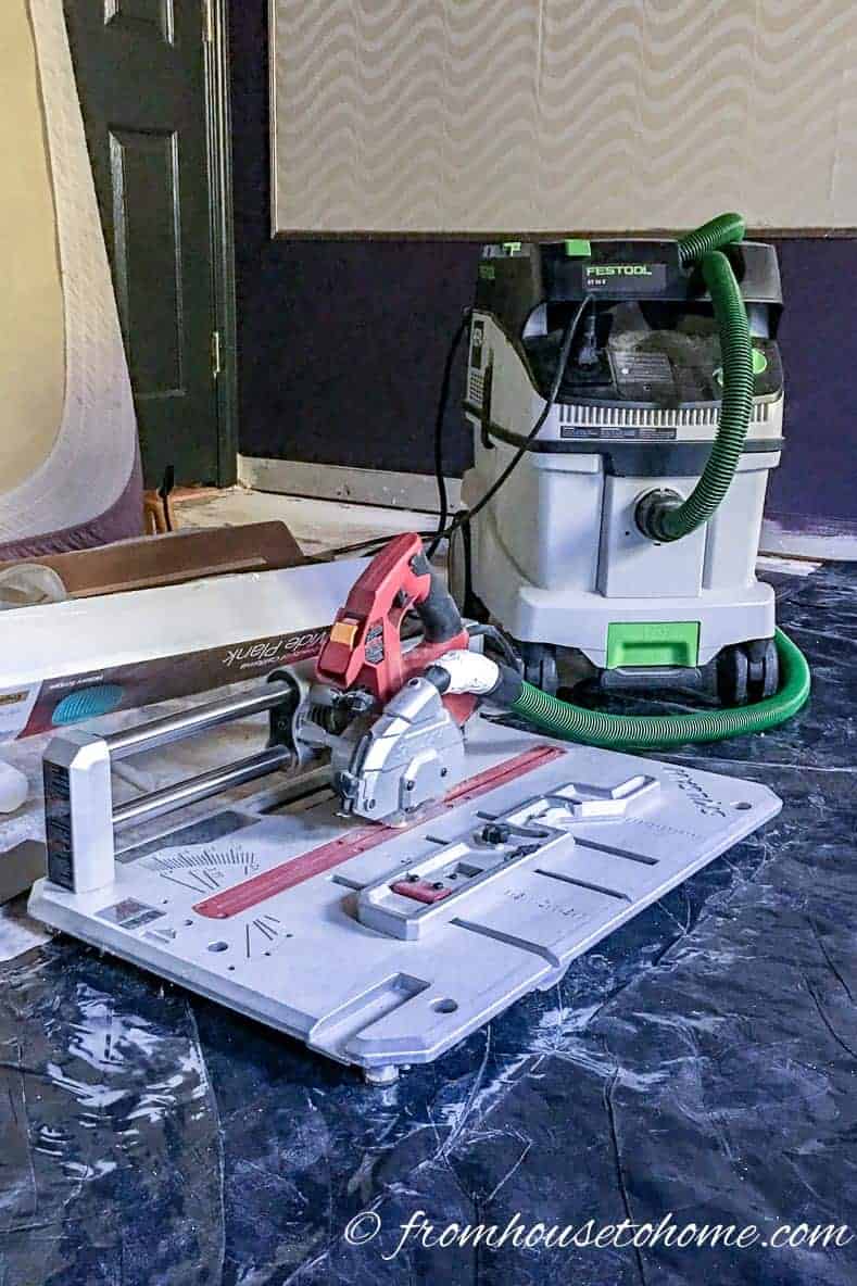 A flooring saw with a Festool dust collector attached to it on the floor