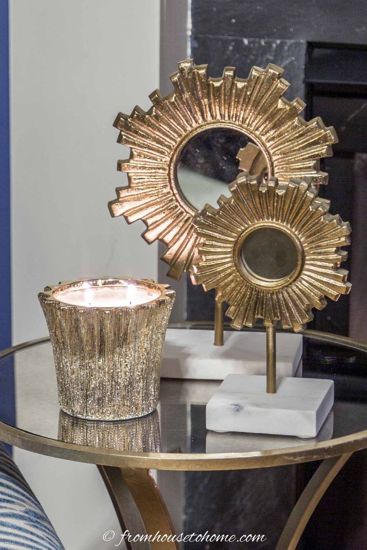 gold candle holder and small mirrors on a table