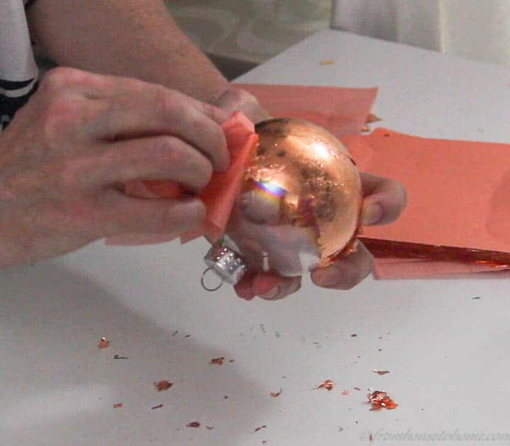 Copper leaf being rubbed off of a glass Christmas ornament