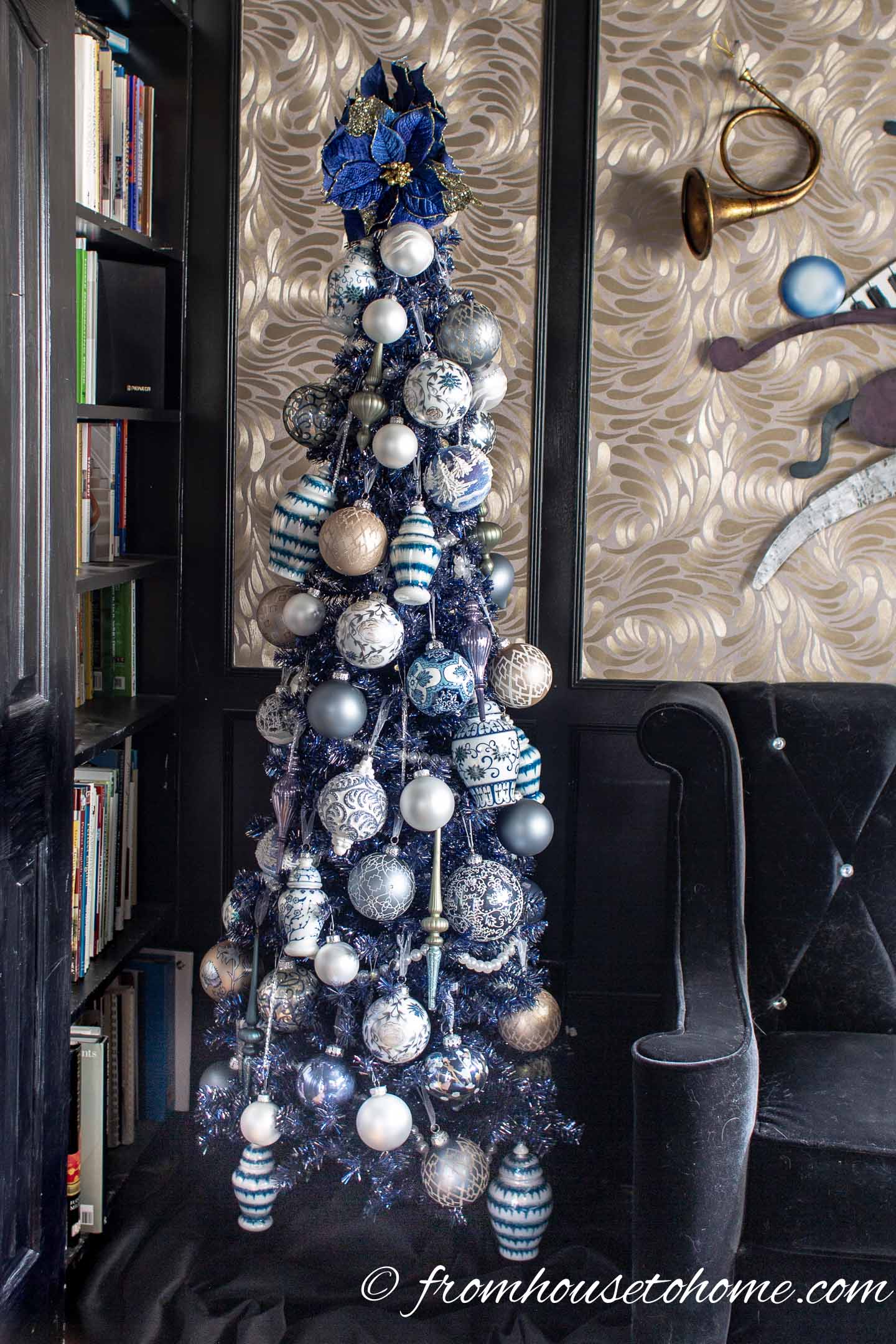 Blue and white ornaments on a blue pencil Christmas tree