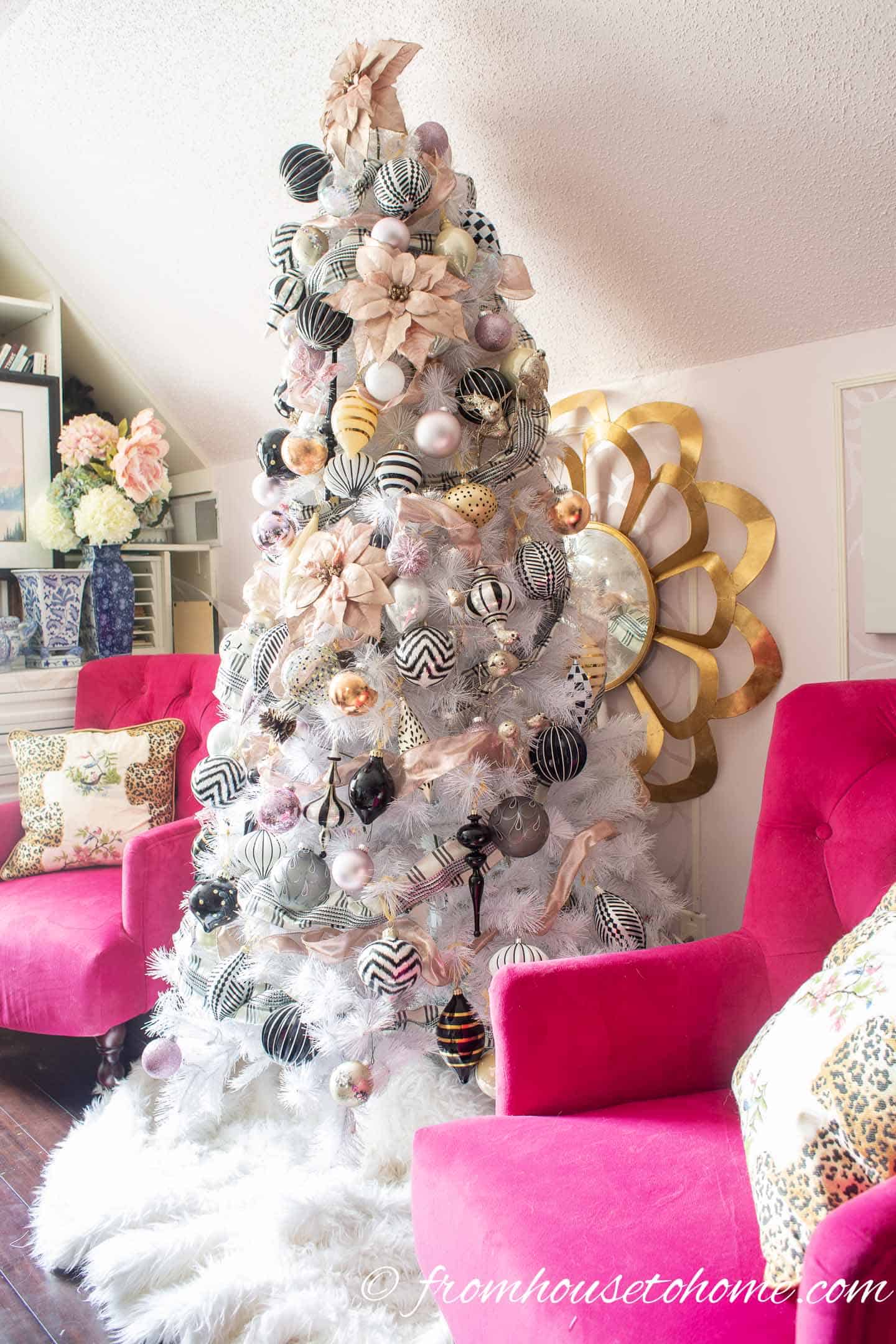 White Christmas tree with pink and black and white ornaments on it