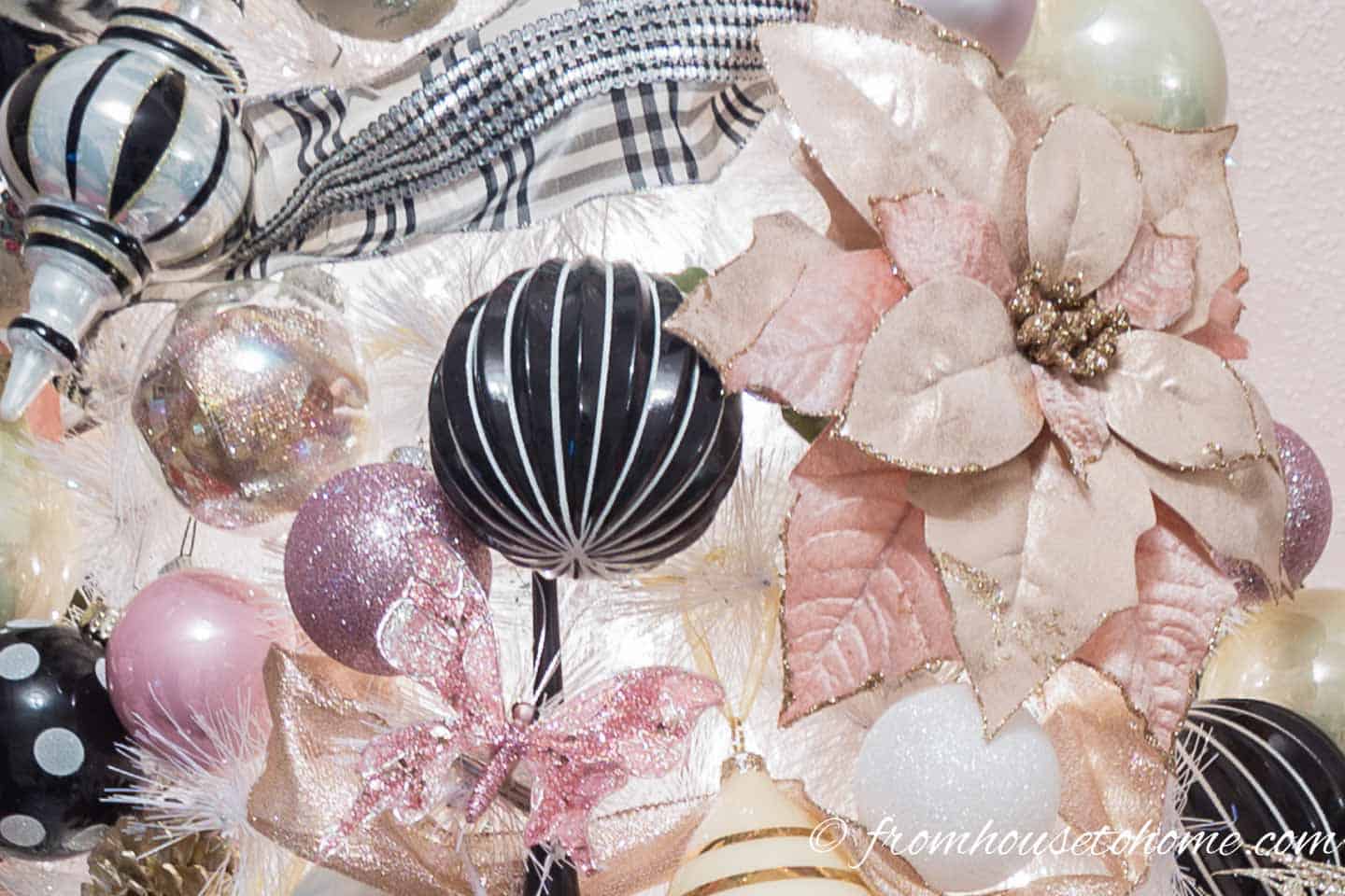 Pink and black and white ornaments on a white Christmas tree
