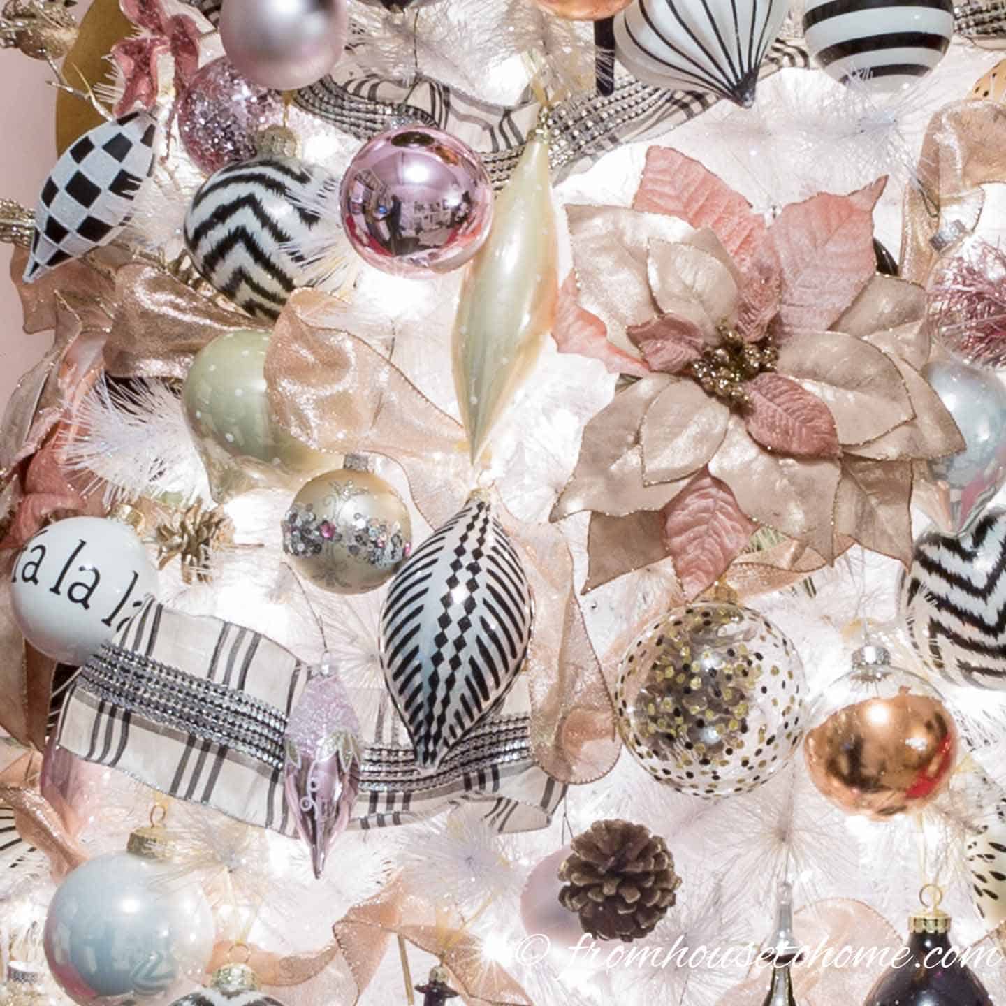 Black and white ornaments with pink ornaments and back and white ribbon on a Christmas tree