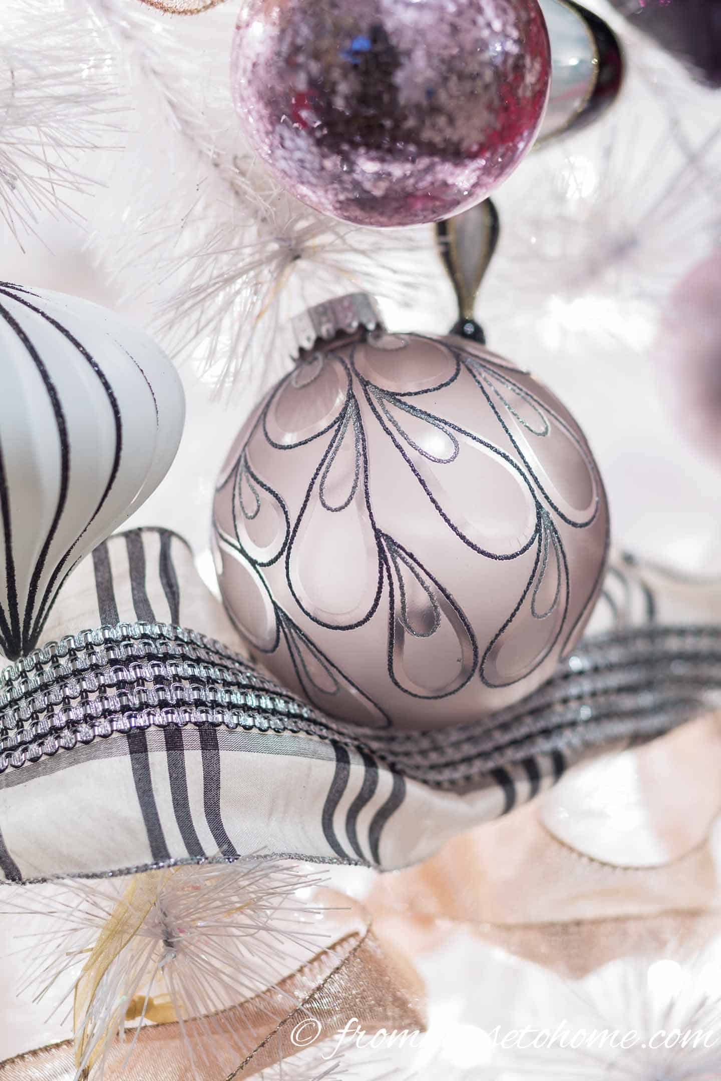 Close up of black and white ornaments and ribbon on a Christmas tree