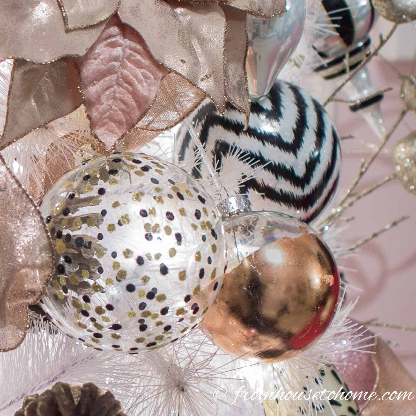 DIY copper leaf Christmas ornament on a white Christmas tree with black and white ornaments