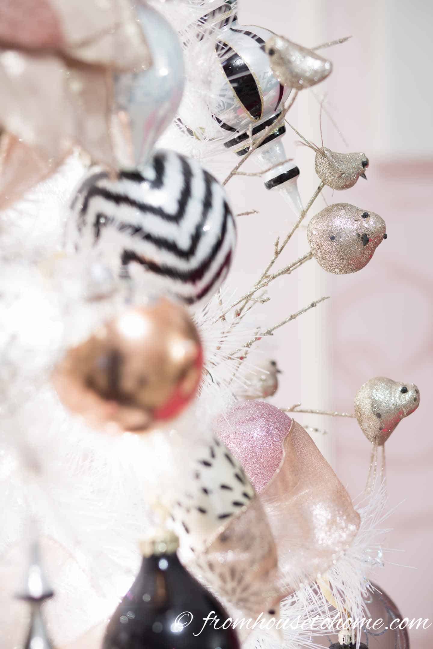 Black, white and gold ornaments on a white Christmas tree
