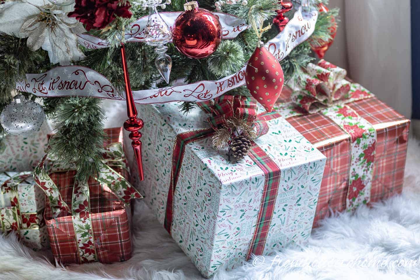 Close up of presents wrapped in white and red wrapping paper under the tree