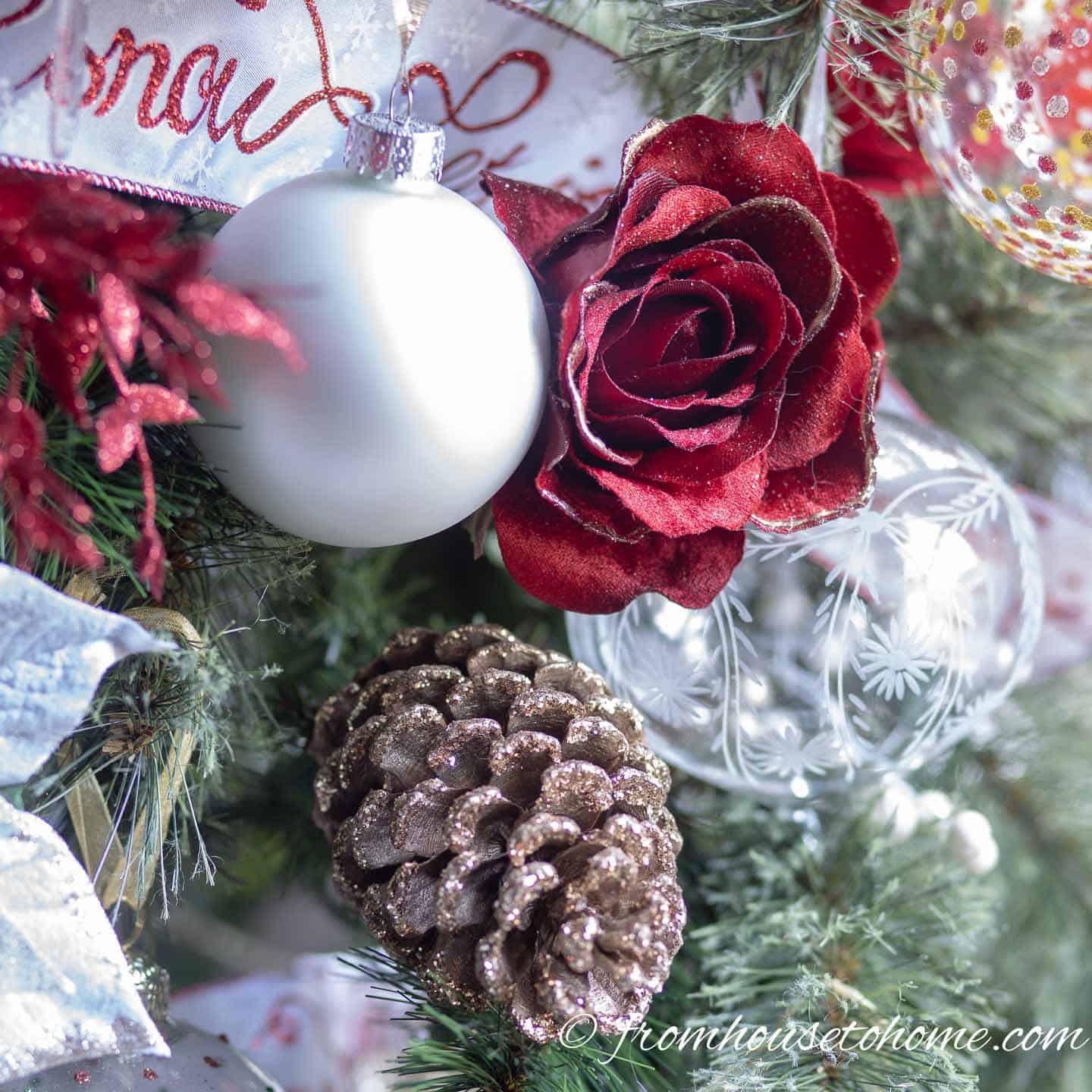 Pine cones and faux roses used as Christmas ornaments on a tree