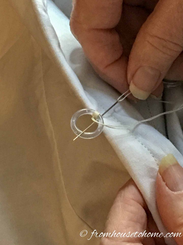 Roman blind ring being sewn onto the fabric with a sewing needle and thread