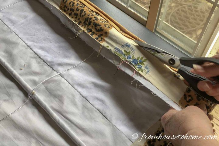 Excess fabric being cut from the Roman shade mounting board