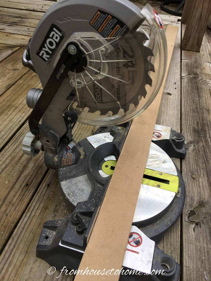 Miter saw with a board being cut for the DIY TV frame