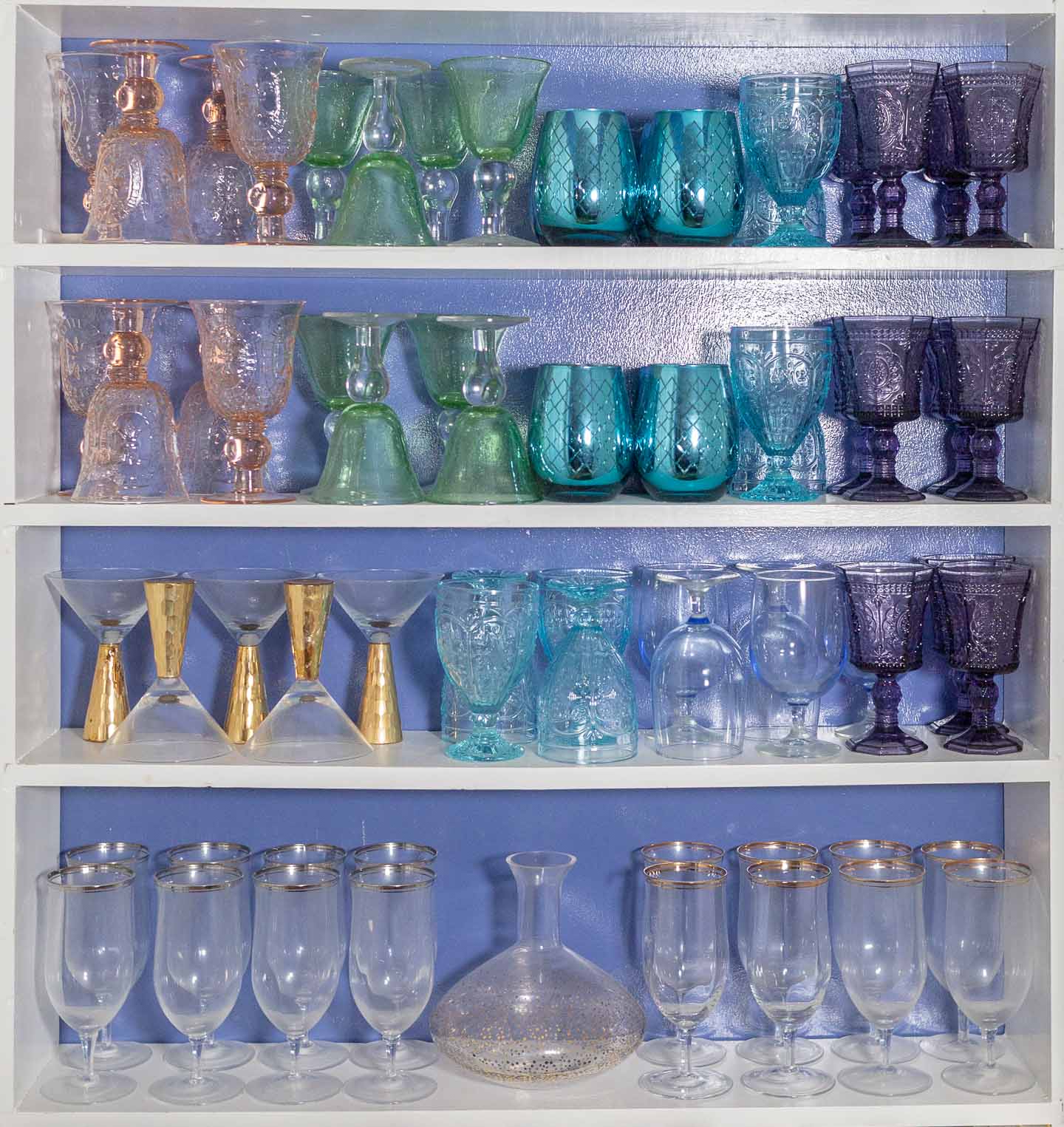 Multi-colored glass collection on white shelves