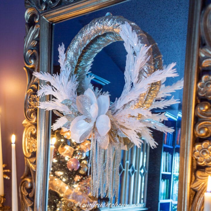 DIY white and gold Christmas wreath hanging on a mirror