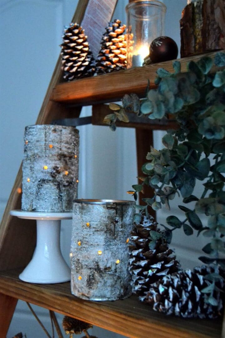 DIY rustic luminaries on a shelf with pine cones