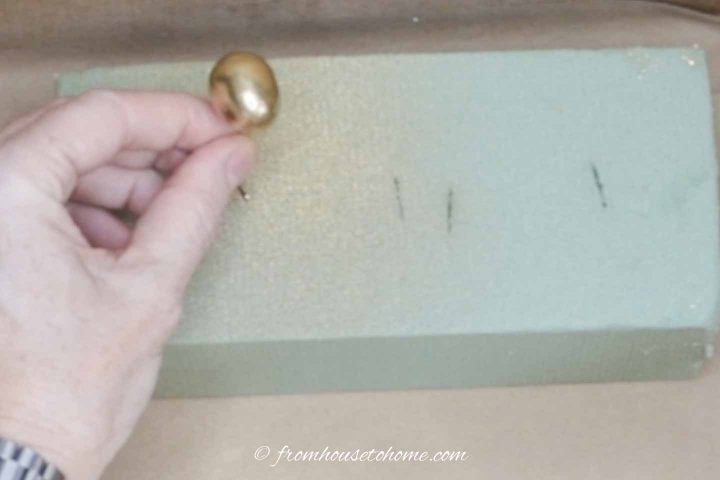 Gold-painted mini egg in floral foam