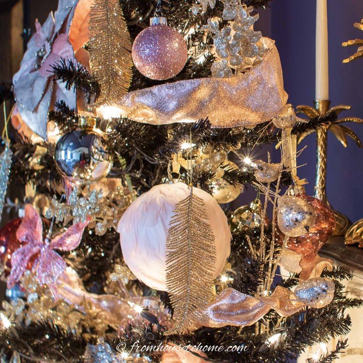 Pink ribbon with pink and gold ornaments on a black Christmas tree