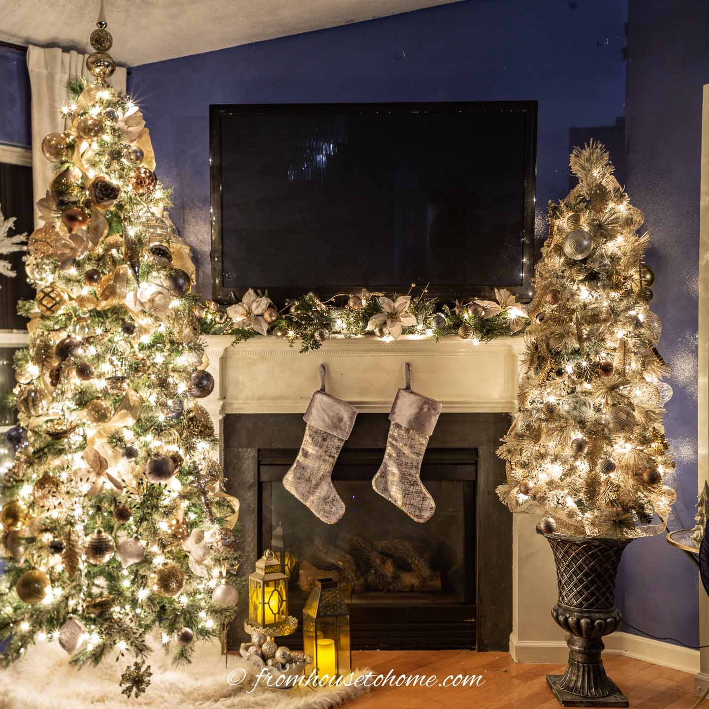 Two Christmas trees on either side of the fireplace, all decorate with gold, silver and copper ornaments