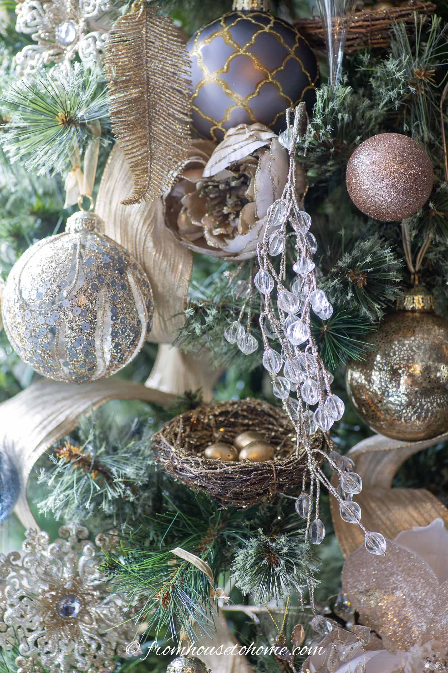 DIY bird's nest ornament on a Christmas tree with gold and silver ornaments