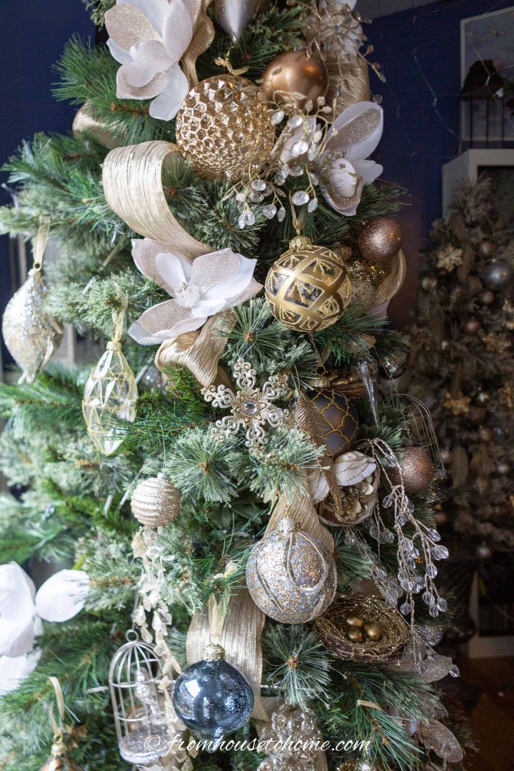 Enfeites de Natal de ouro, prata e cobre em uma árvore de Natal de metais mistos