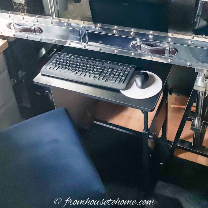 Keyboard and mouse on a laptop stand in front of a desk