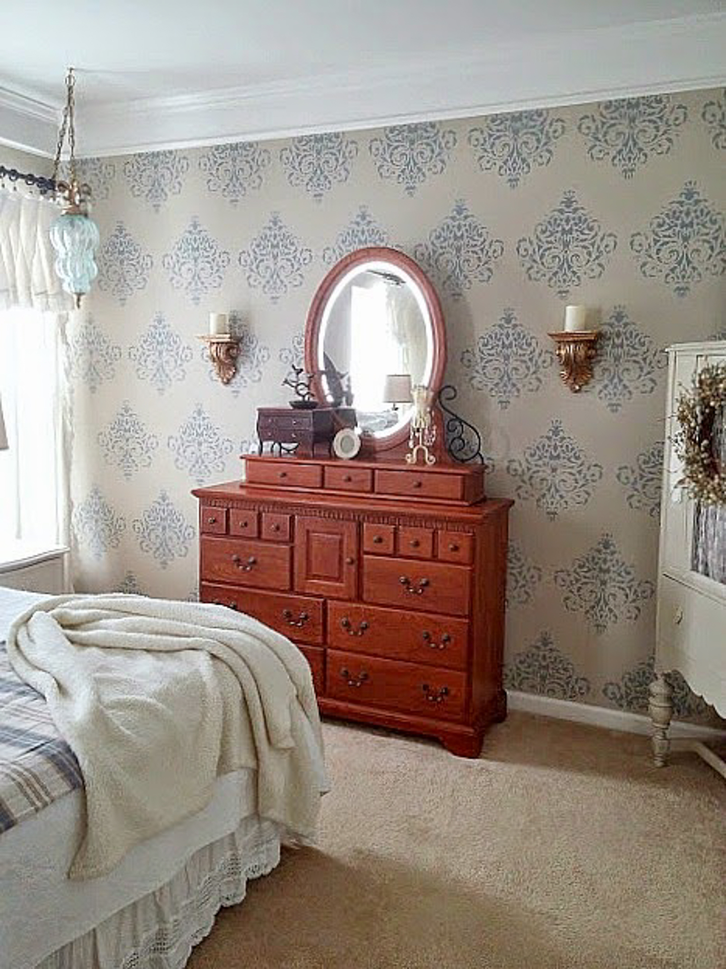 Bedroom wall painted with a damask stencil via diybeautify.com