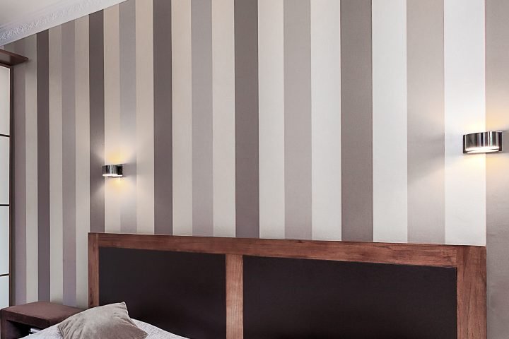 Bedroom wall with vertical stripes in different shades of gray and white