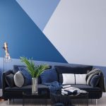 blue living room with triangle design painted on the wall behind the couch