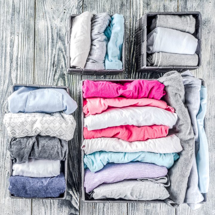 Clothing folded in envelopes and stored vertically in baskets