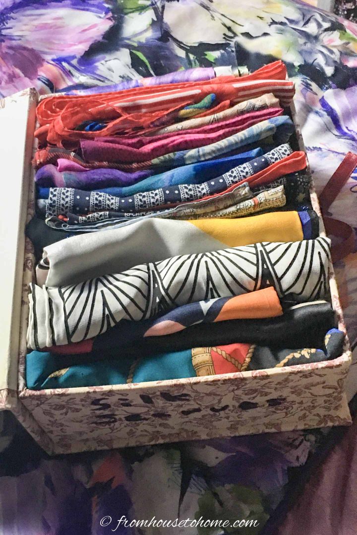 Clothes organized by color in a storage box with a label