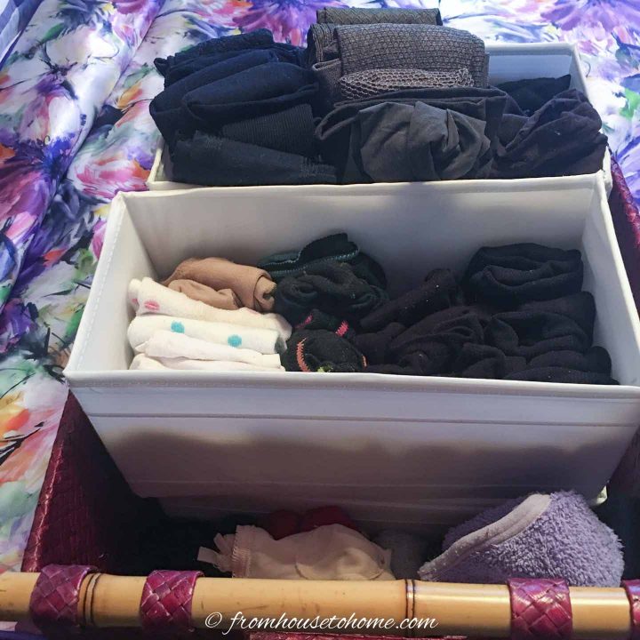 Small cloth bins with socks stacked inside a larger storage basket