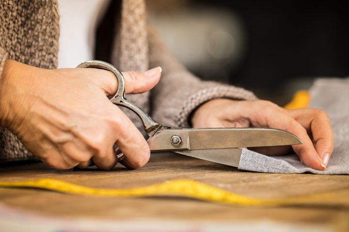 Woman cutting fabric with scissors