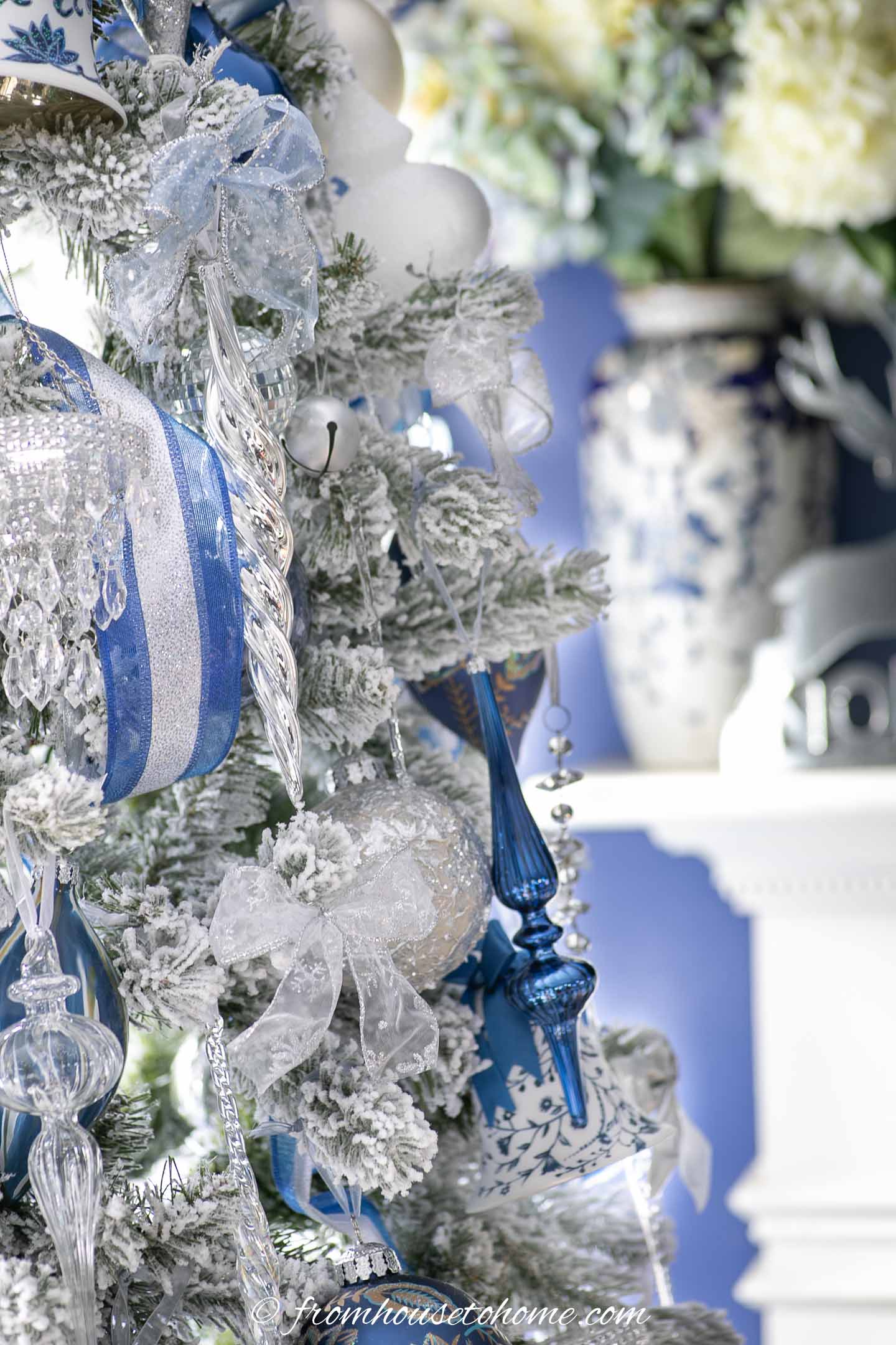 blue, white and clear glass finial ornaments on a flocked christmas tree