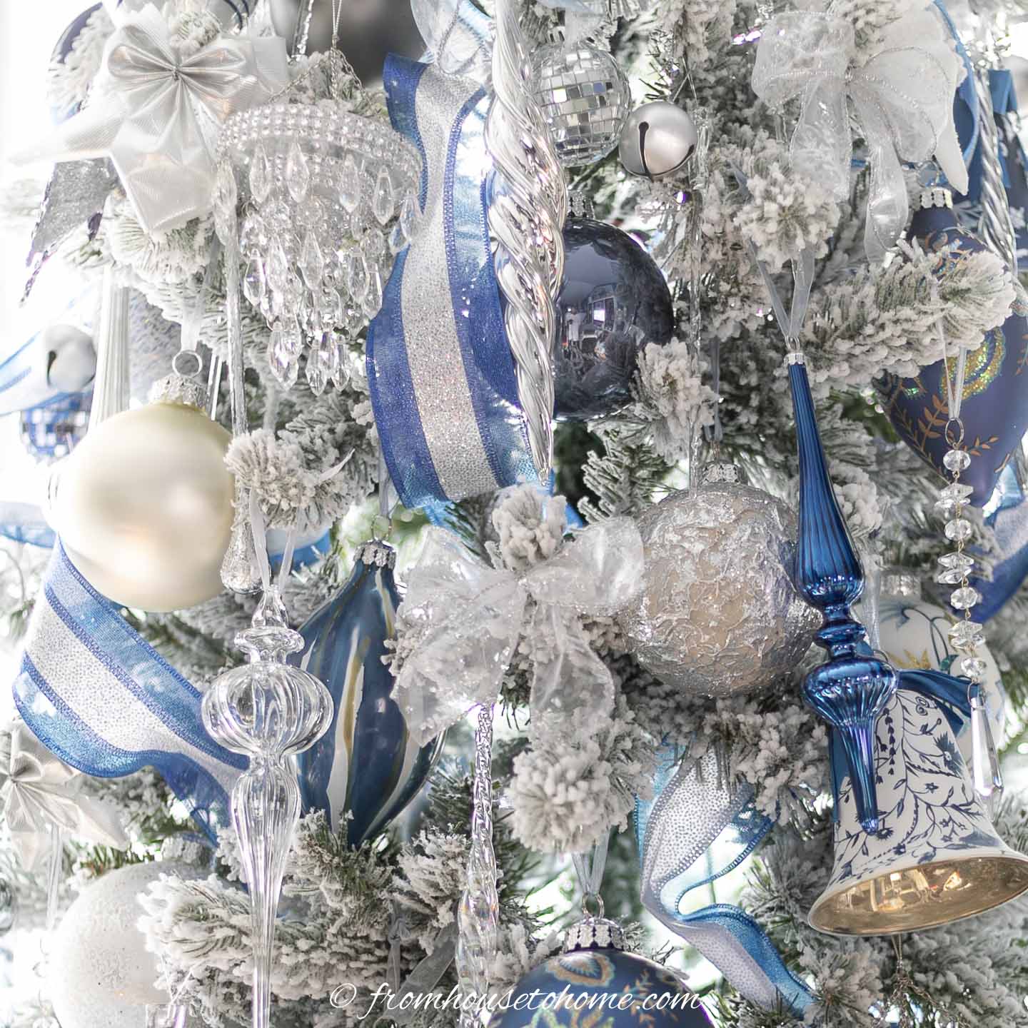 Large ball ornaments, ribbons and crystal ornaments on a flocked christmas tree