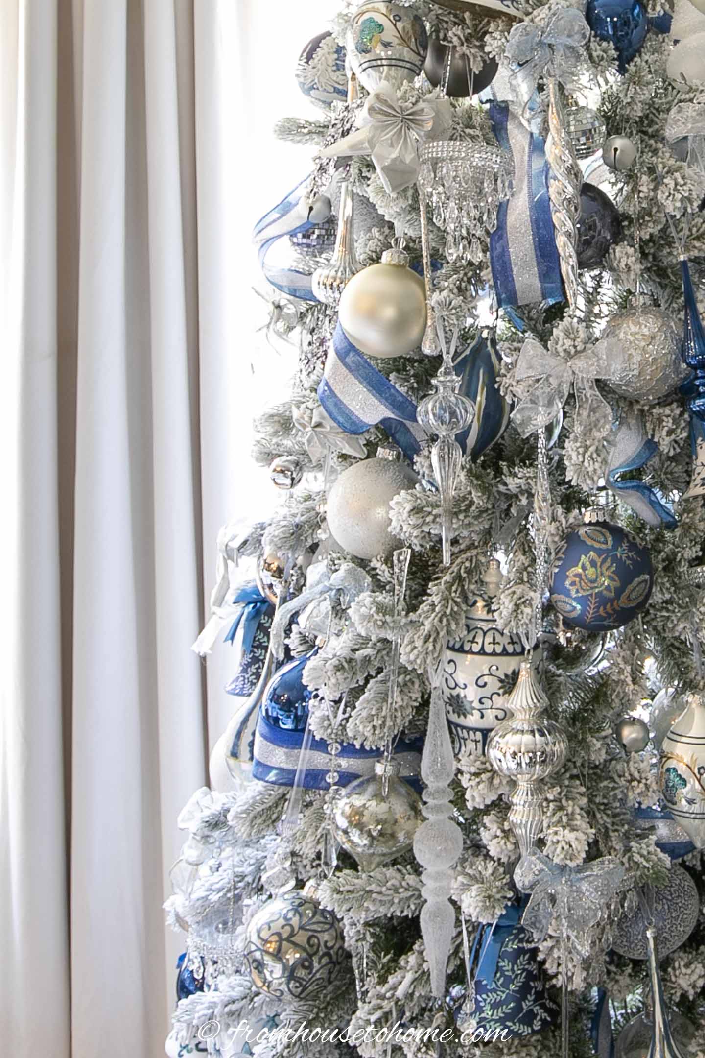 blue and white ribbon with blue, white and silver ornaments on a christmas tree