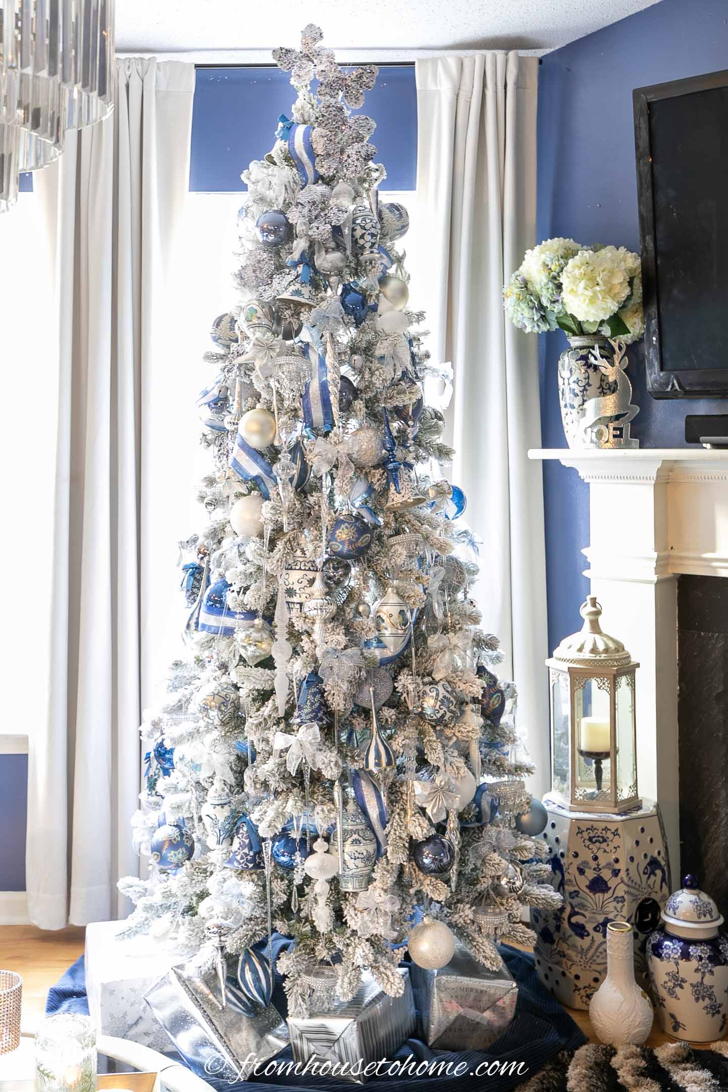 white, royal blue and silver ornaments on a flocked christmas tree