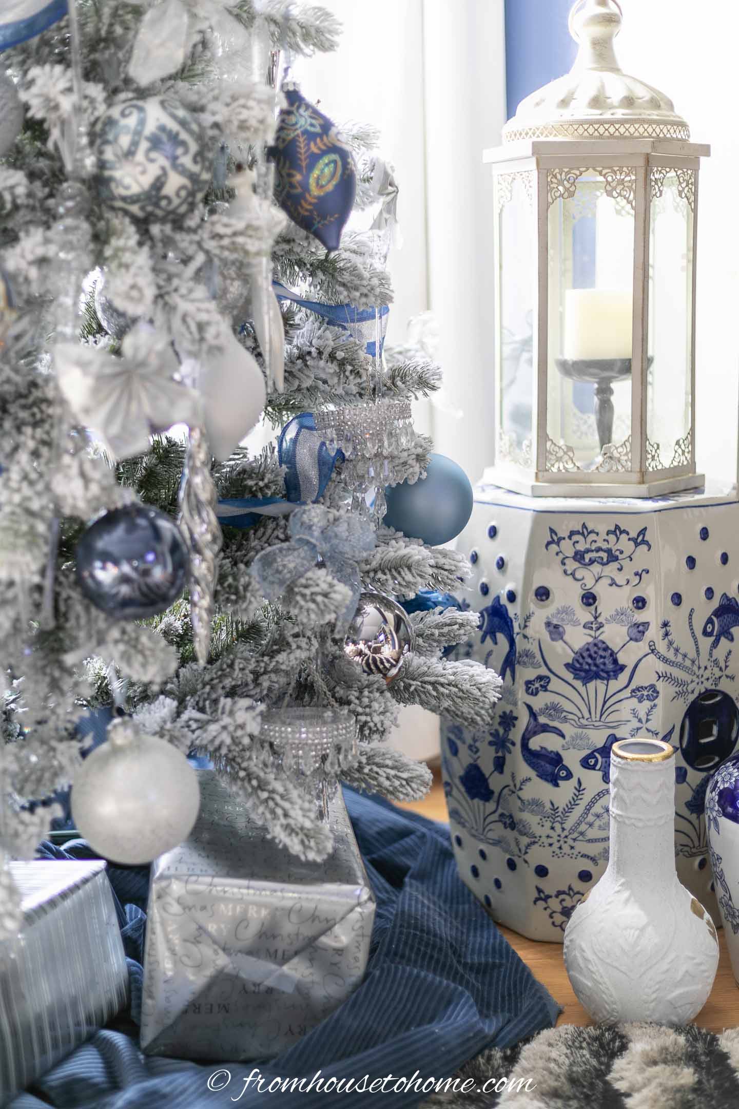 blue and white garden stool beside a wintry white, blue and silver christmas tree