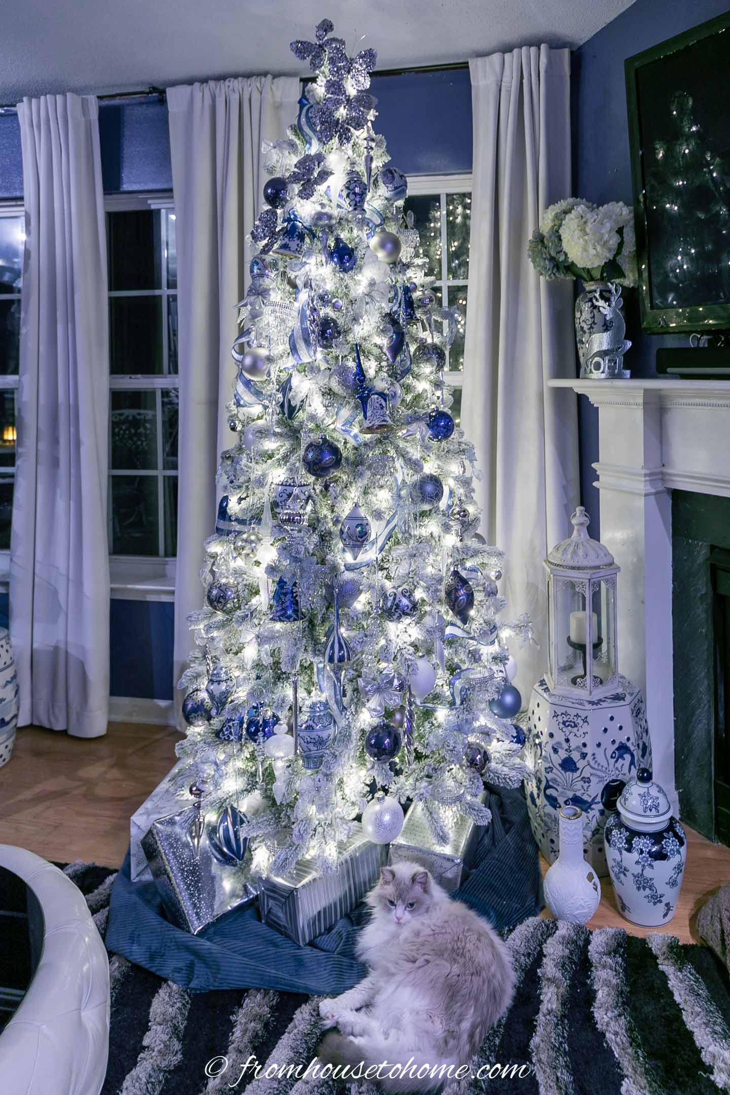 Wintry white, blue and silver christmas tree with the lights on at night