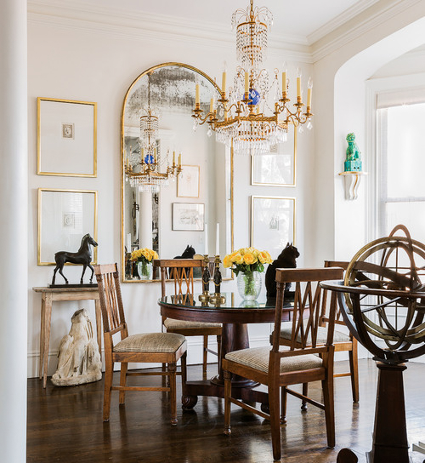 A large mirror with two pictures on either side in a dining room