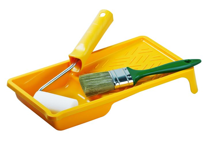 Paint tray with a foam roller and a paint brush