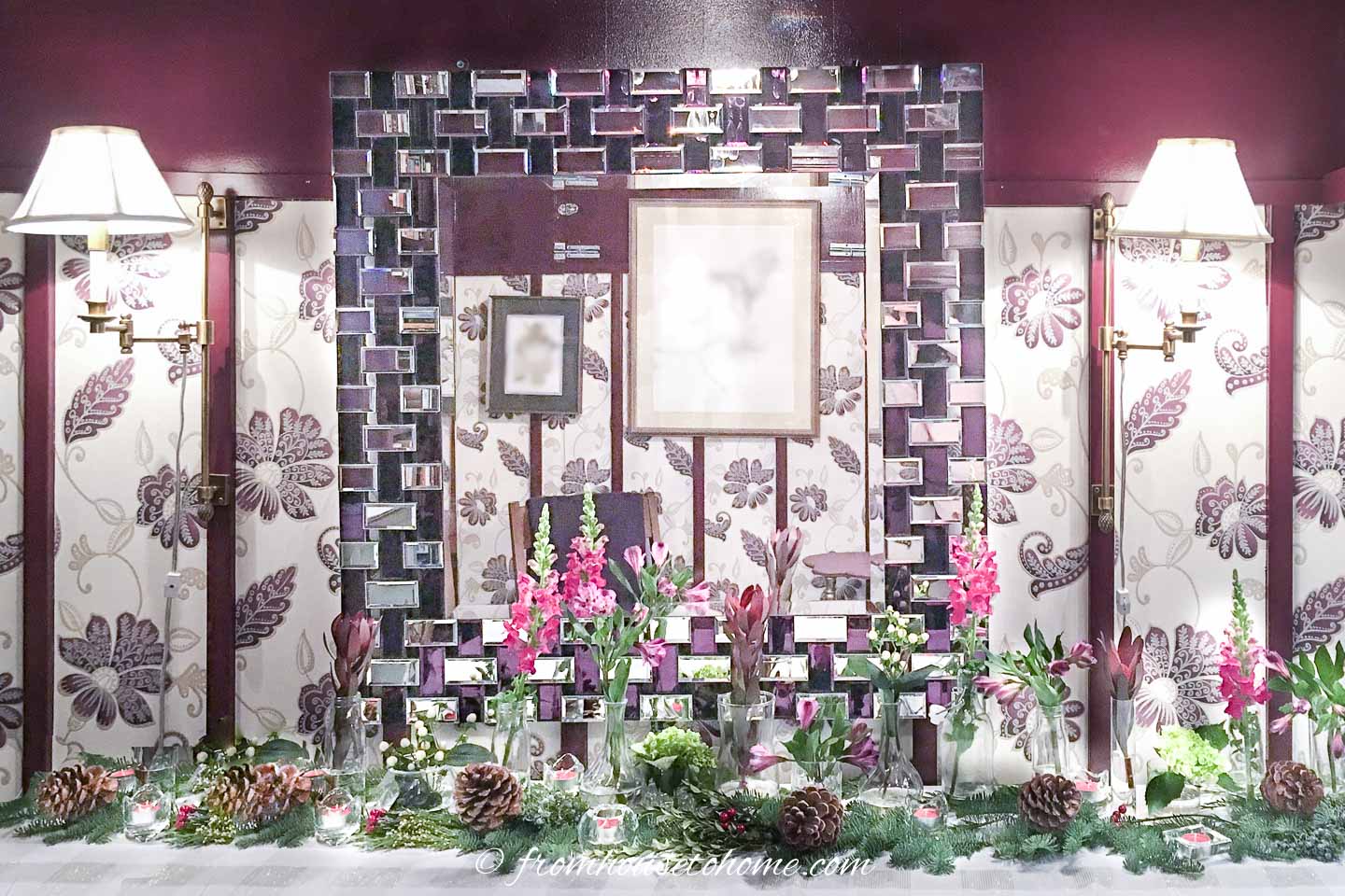 Two sconces on either side of a large mirror in a paneled room