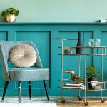 2021 home decor trends: Teal chair and wall with brass bar cart