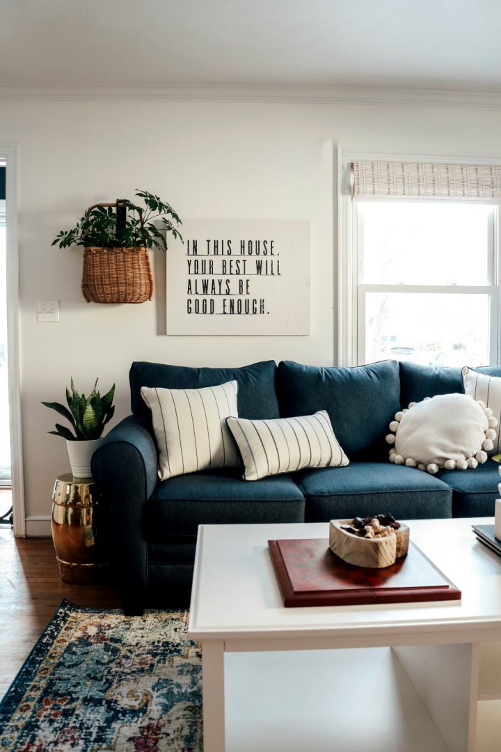 A typography print on a white wood canvas above a sofa. 