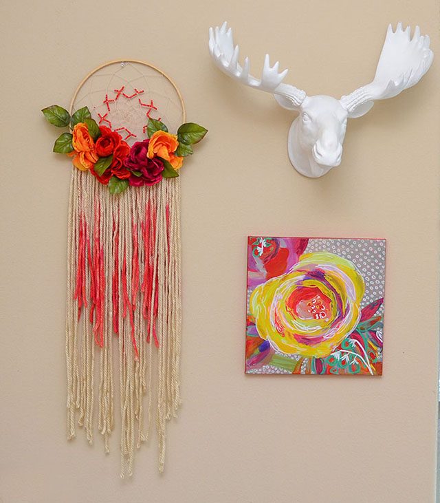 A dreamcatcher, faux animal head and art canvas as wall decor. 
