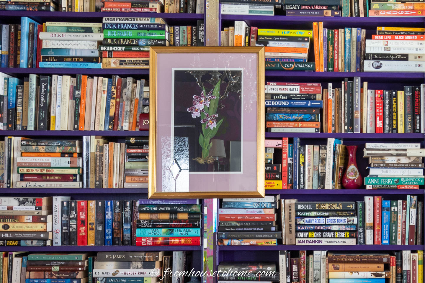 A piece of art hung on a bookshelf filled with books