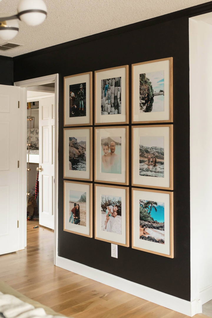 Large family photos in uniform frames on a black wall. 