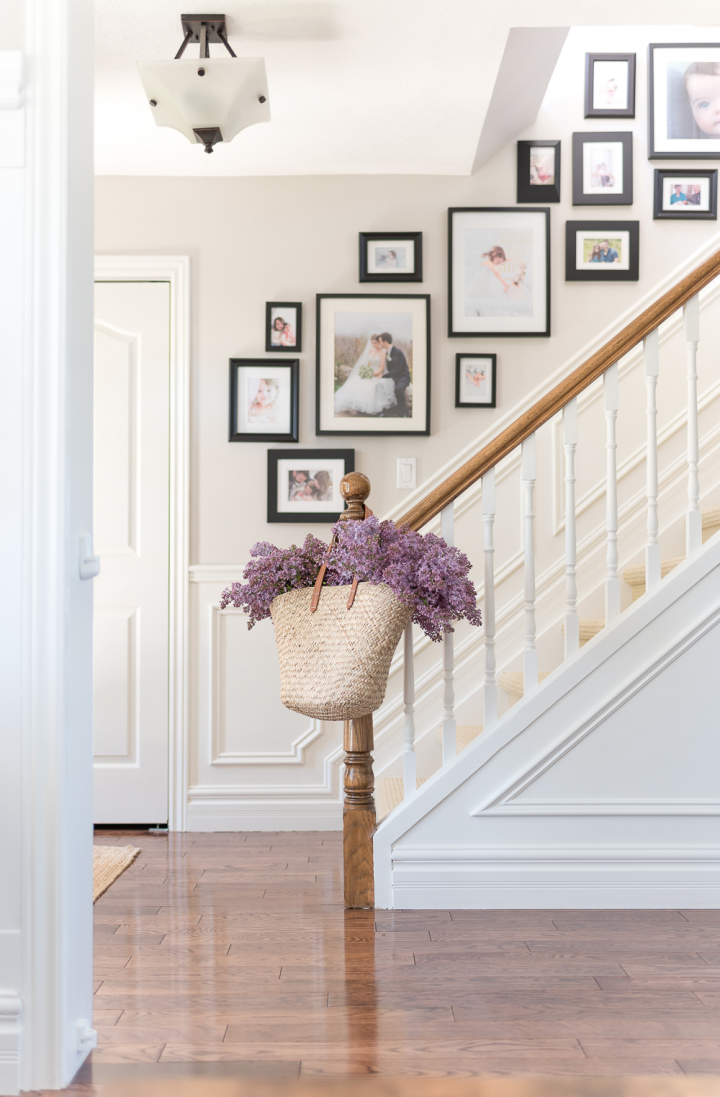 A gallery wall of black framed photographs mounted along a staircase. 