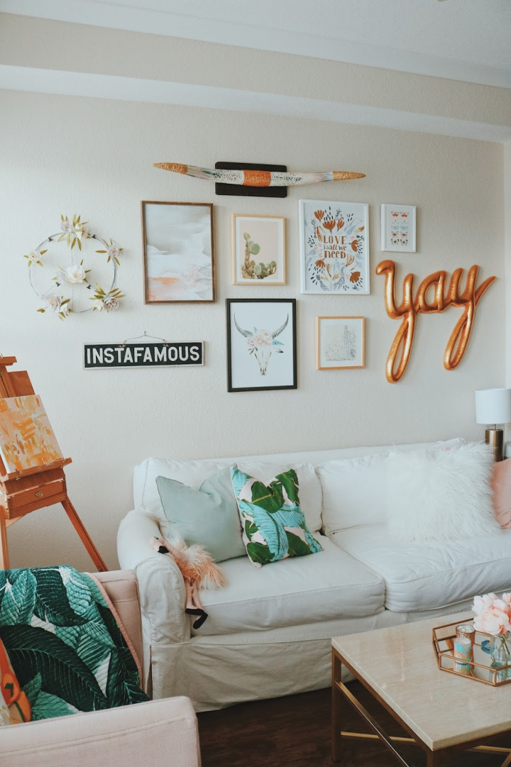 A boho style gallery wall with copper accents over a white sofa. 