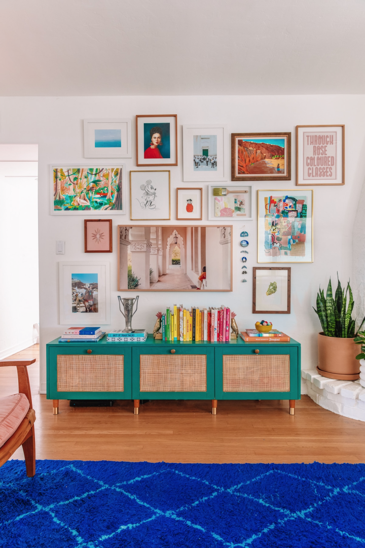 A colorful gallery wall with mixed frame style and colors. 